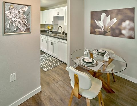 a dining room with a glass table and a kitchen